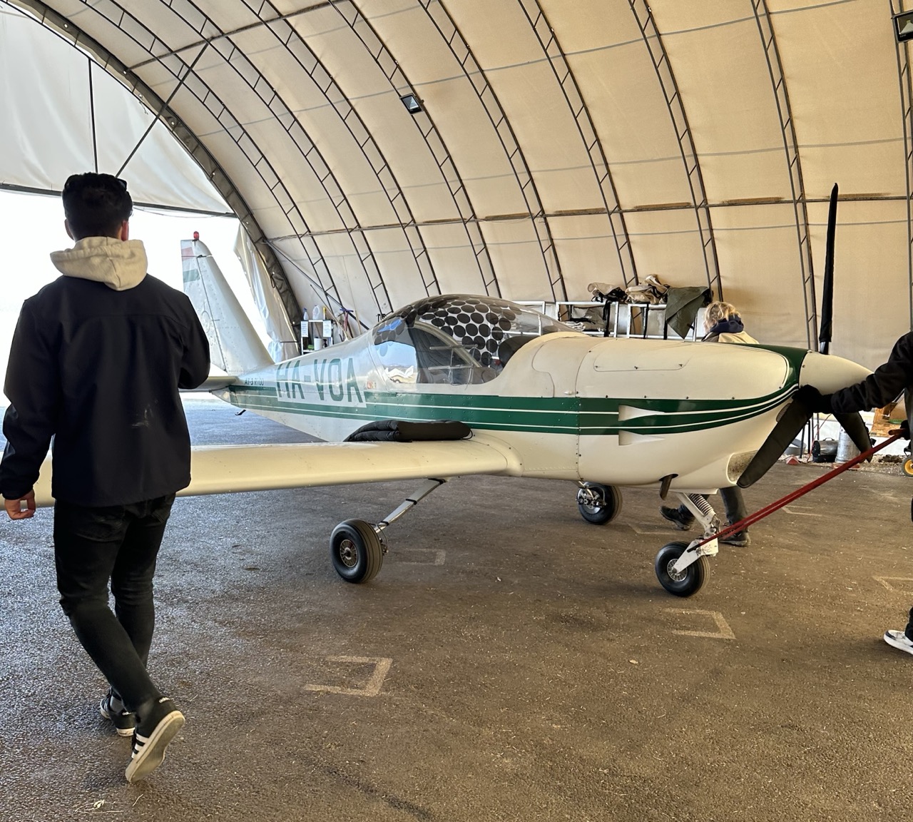 The plane being towed out of the hangar